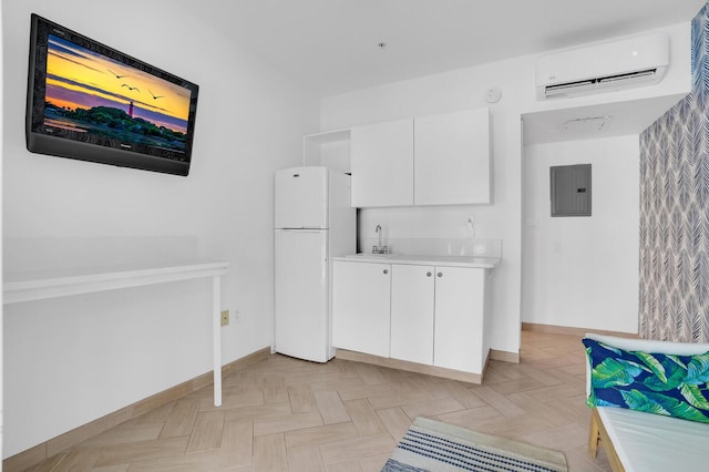 120 Ocean Grande Blvd Unit 302, Jupiter, FL 33477 - kitchen with freestanding refrigerator, a wall mounted AC, electric panel, light countertops, and white cabinetry