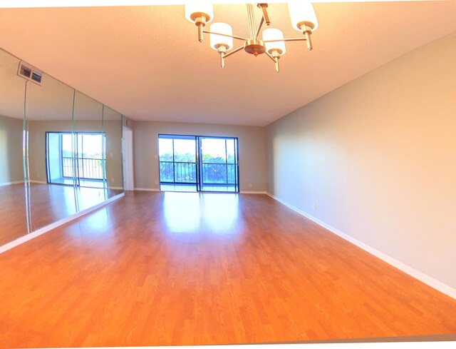 7076 Huntington Ln Unit 404, Delray Beach, FL 33446 - spare room featuring a chandelier and wood finished floors