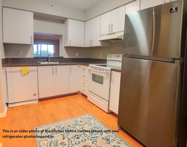 7076 Huntington Ln Unit 404, Delray Beach, FL 33446 - kitchen with white appliances, under cabinet range hood, dark countertops, light wood-style floors, and white cabinets