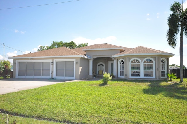 6771 NW Daffodil Ln, Port Saint Lucie, FL 34983 - mediterranean / spanish home featuring concrete driveway, an attached garage, a front lawn, stucco siding, and a shingled roof