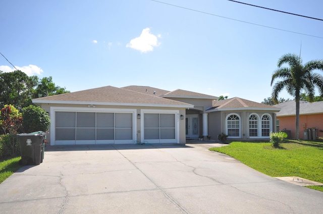 6771 NW Daffodil Ln, Port Saint Lucie, FL 34983 - view of front of home with a garage, concrete driveway, a front lawn, stucco siding, and french doors