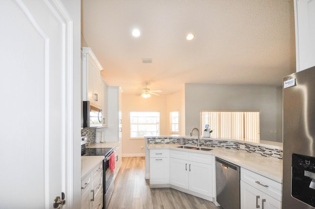 6771 NW Daffodil Ln, Port Saint Lucie, FL 34983 - kitchen featuring stainless steel appliances, tasteful backsplash, light wood-style flooring, white cabinetry, and recessed lighting