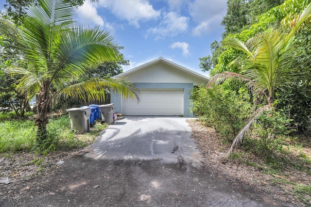 1966 9th St, Vero Beach, FL 32960 - view of side of home featuring asphalt driveway and a garage