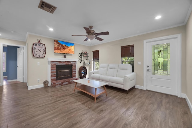 1966 9th St, Vero Beach, FL 32960 - living room with crown molding, recessed lighting, ceiling fan, a fireplace, and wood finished floors