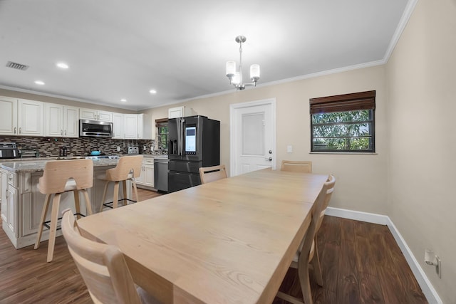 1966 9th St, Vero Beach, FL 32960 - dining area featuring plenty of natural light, ornamental molding, wood finished floors, recessed lighting, and a chandelier