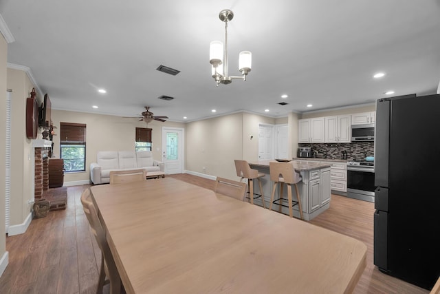 1966 9th St, Vero Beach, FL 32960 - dining room featuring ornamental molding, light wood finished floors, ceiling fan, recessed lighting, and a chandelier