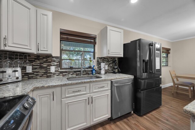 1966 9th St, Vero Beach, FL 32960 - kitchen featuring stainless steel appliances, backsplash, white cabinets, wood finished floors, and crown molding