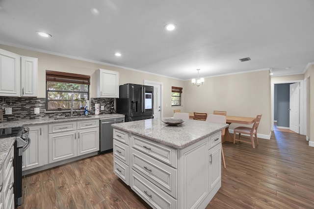 1966 9th St, Vero Beach, FL 32960 - kitchen with stainless steel appliances, a chandelier, backsplash, healthy amount of natural light, and ornamental molding