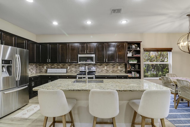 244 Behring Way, Jupiter, FL 33458 - kitchen with stainless steel appliances, backsplash, light stone countertops, a kitchen breakfast bar, and recessed lighting
