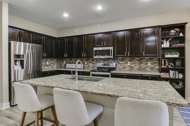 244 Behring Way, Jupiter, FL 33458 - kitchen featuring appliances with stainless steel finishes, light wood-style floors, tasteful backsplash, a kitchen breakfast bar, and recessed lighting