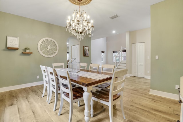 244 Behring Way, Jupiter, FL 33458 - dining space with arched walkways, light wood finished floors, stairs, recessed lighting, and a chandelier