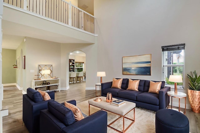 244 Behring Way, Jupiter, FL 33458 - living area with arched walkways, a high ceiling, and wood finished floors