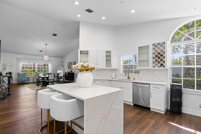 5160 Sabal Gardens Ln Unit 1, Boca Raton, FL 33487 - kitchen with dishwasher, a breakfast bar area, backsplash, light stone counters, and dark wood-type flooring