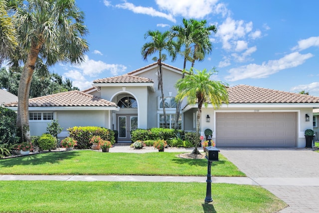 12388 Lakeridge Falls Dr, Boynton Beach, FL 33437 - mediterranean / spanish-style house with french doors, a tile roof, stucco siding, and a garage