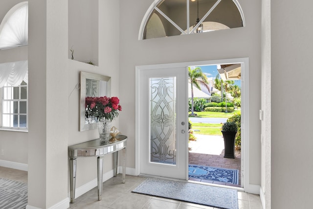 12388 Lakeridge Falls Dr, Boynton Beach, FL 33437 - entryway featuring healthy amount of natural light, tile patterned floors, a towering ceiling, and a chandelier