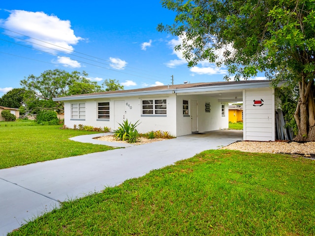 640 Beach Ave, Port Saint Lucie, FL 34952 - view of front of house with concrete driveway, a carport, a front yard, and stucco siding