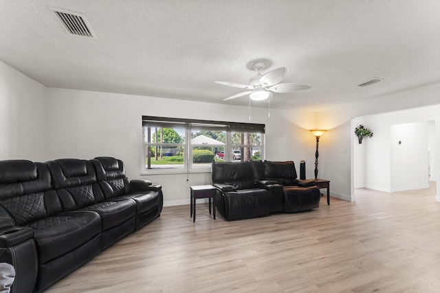 1144 NW 12th Ter, Stuart, FL 34994 - living area with light wood-type flooring, a ceiling fan, and a textured ceiling