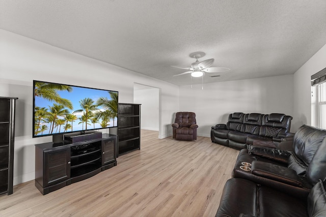1144 NW 12th Ter, Stuart, FL 34994 - living area featuring light wood-style floors, a ceiling fan, and a textured ceiling