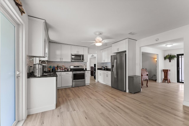 1144 NW 12th Ter, Stuart, FL 34994 - kitchen with stainless steel appliances, tasteful backsplash, light wood-style floors, ceiling fan, and white cabinetry