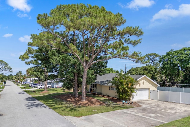 1144 NW 12th Ter, Stuart, FL 34994 - view of front of home featuring an attached garage, concrete driveway, and stucco siding
