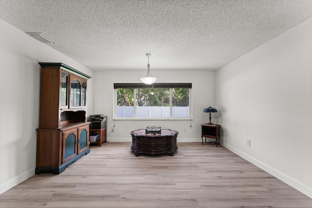 1144 NW 12th Ter, Stuart, FL 34994 - living area featuring light wood-style floors and a textured ceiling
