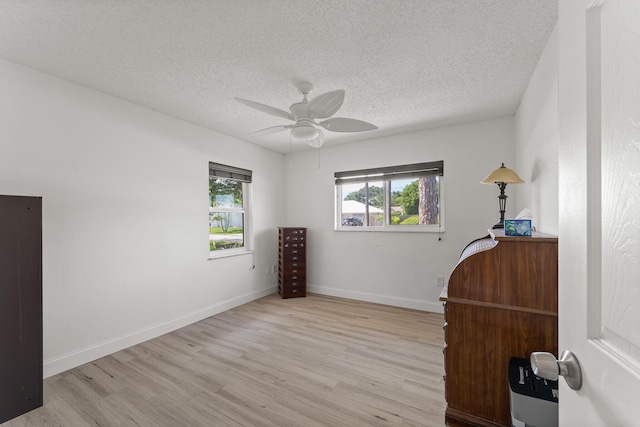 1144 NW 12th Ter, Stuart, FL 34994 - bedroom featuring multiple windows, light wood-type flooring, a textured ceiling, and ceiling fan