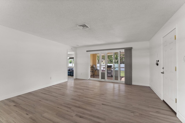 1144 NW 12th Ter, Stuart, FL 34994 - unfurnished living room with a textured ceiling and wood finished floors