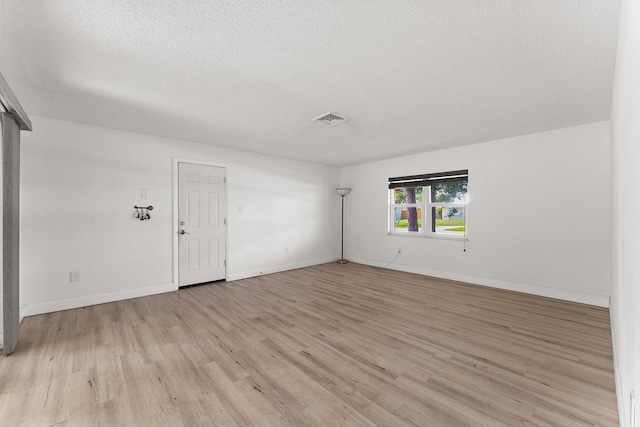 1144 NW 12th Ter, Stuart, FL 34994 - unfurnished room featuring light wood finished floors and a textured ceiling