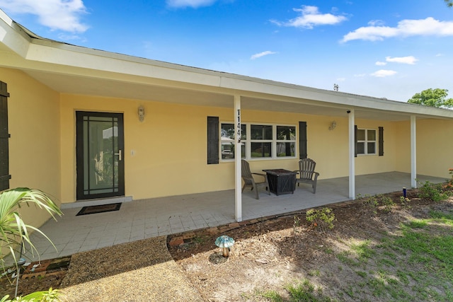 1144 NW 12th Ter, Stuart, FL 34994 - back of house with stucco siding and a patio area