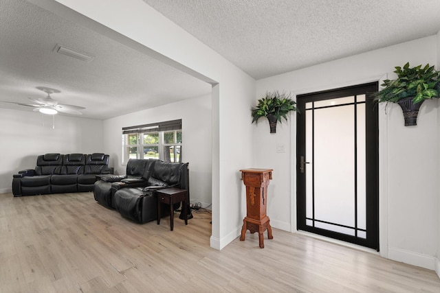 1144 NW 12th Ter, Stuart, FL 34994 - living area featuring light wood-type flooring, a textured ceiling, and ceiling fan