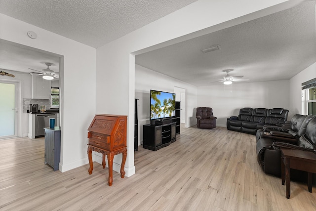 1144 NW 12th Ter, Stuart, FL 34994 - living room featuring a ceiling fan, light wood-style floors, and a textured ceiling