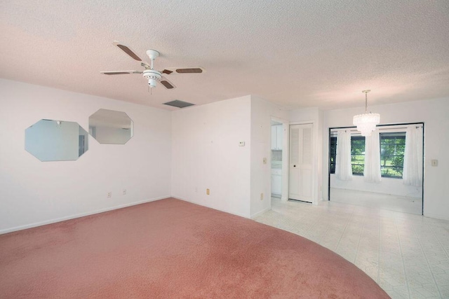 325 SE Bayview Ter, Port Saint Lucie, FL 34983 - empty room with a textured ceiling, ceiling fan, a chandelier, and light colored carpet