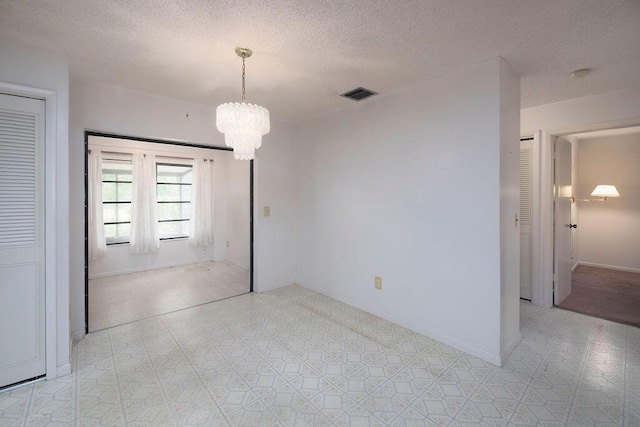 325 SE Bayview Ter, Port Saint Lucie, FL 34983 - empty room featuring a chandelier, a textured ceiling, and a smoke detector