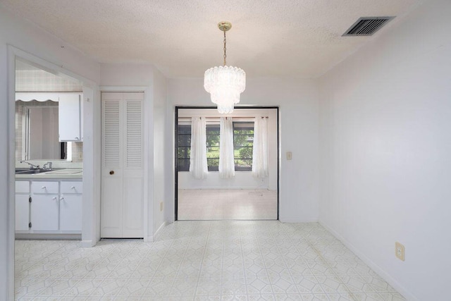 325 SE Bayview Ter, Port Saint Lucie, FL 34983 - unfurnished dining area with a chandelier and a textured ceiling
