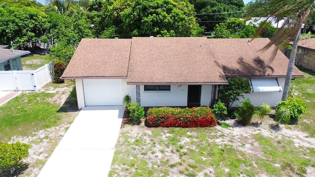 325 SE Bayview Ter, Port Saint Lucie, FL 34983 - view of front facade featuring a garage, a gate, stucco siding, concrete driveway, and roof with shingles