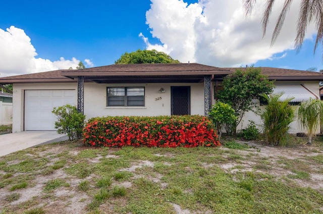 325 SE Bayview Ter, Port Saint Lucie, FL 34983 - view of front of property with a garage, stucco siding, and driveway