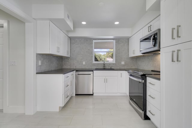 334 SW 14 Th Ave, Boynton Beach, FL 33435 - kitchen featuring appliances with stainless steel finishes, dark countertops, tasteful backsplash, white cabinetry, and recessed lighting