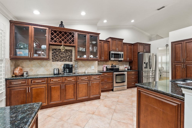 468 SW Prado Ave, Port Saint Lucie, FL 34983 - kitchen with stainless steel appliances, vaulted ceiling, backsplash, ornamental molding, and dark stone countertops