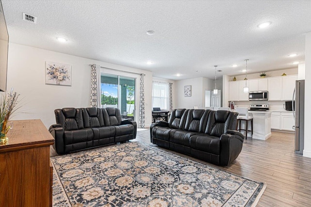 5371 NW Almond Ave, Port Saint Lucie, FL 34986 - living room with a textured ceiling, light wood-type flooring, and recessed lighting