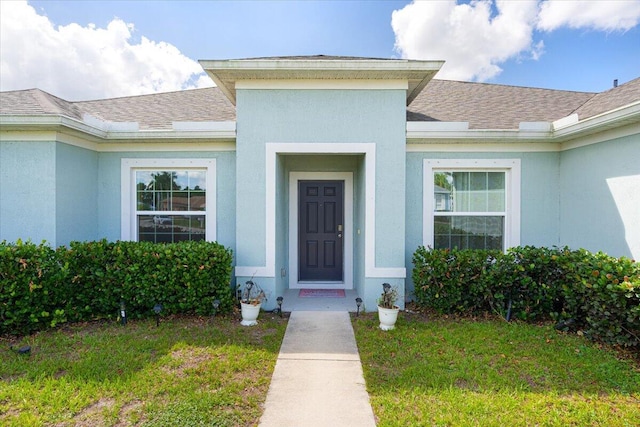 5371 NW Almond Ave, Port Saint Lucie, FL 34986 - entrance to property with a lawn, a shingled roof, and stucco siding