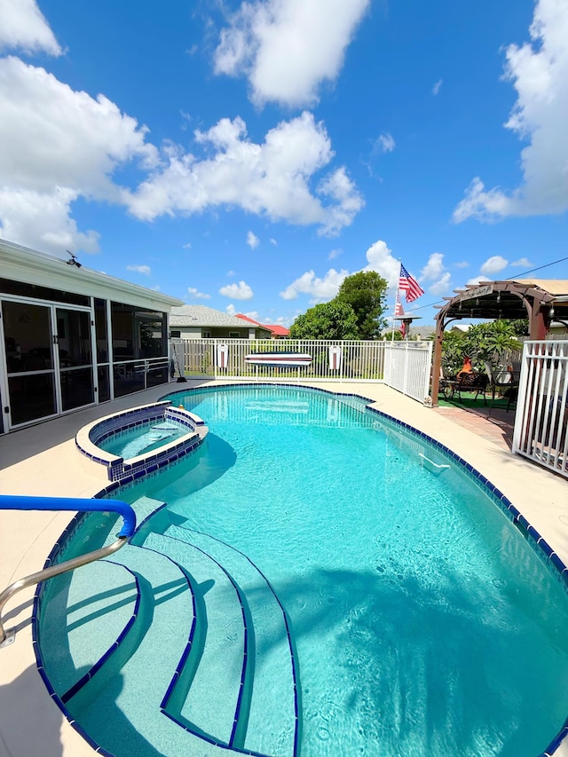 637 SW Sail Ter, Port Saint Lucie, FL 34953 - view of swimming pool featuring a pool with connected hot tub, a sunroom, and a patio area
