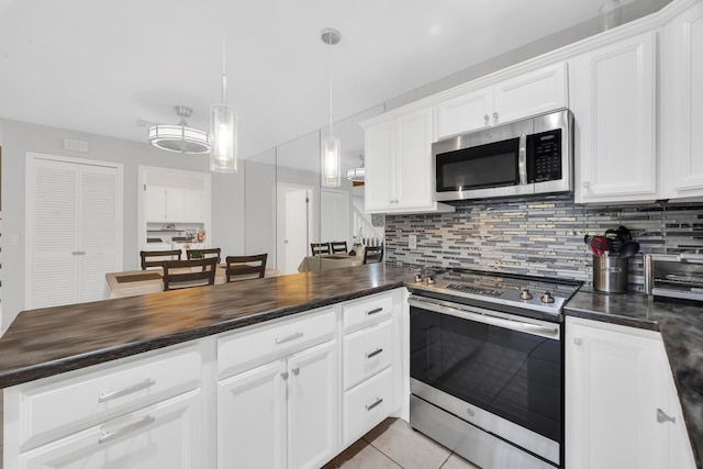 2004 SE Round Table Dr Unit 0, Port Saint Lucie, FL 34952 - kitchen with appliances with stainless steel finishes, decorative backsplash, white cabinetry, and light tile patterned flooring