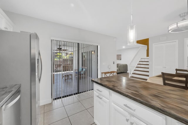 2004 SE Round Table Dr Unit 0, Port Saint Lucie, FL 34952 - kitchen featuring stainless steel appliances, light tile patterned floors, white cabinets, wood counters, and pendant lighting