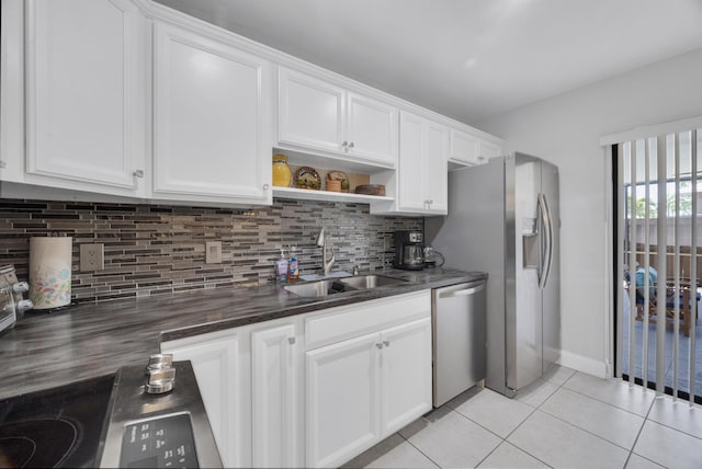 2004 SE Round Table Dr Unit 0, Port Saint Lucie, FL 34952 - kitchen featuring appliances with stainless steel finishes, light tile patterned floors, tasteful backsplash, white cabinetry, and open shelves