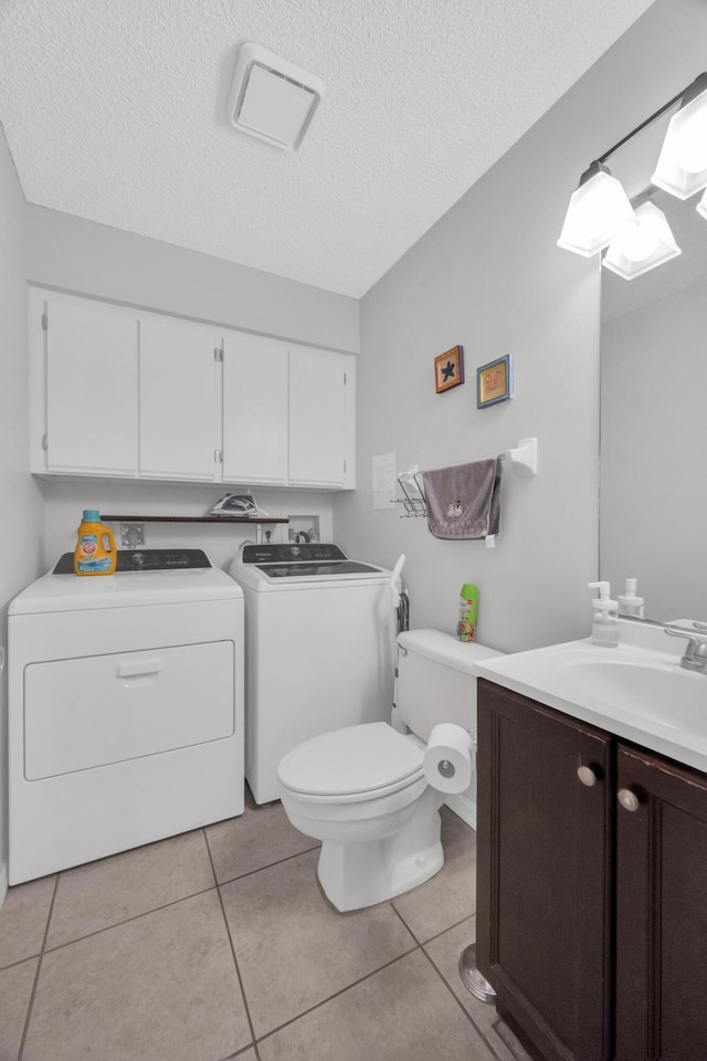 2004 SE Round Table Dr Unit 0, Port Saint Lucie, FL 34952 - bathroom with washing machine and clothes dryer, vanity, a textured ceiling, and tile patterned flooring