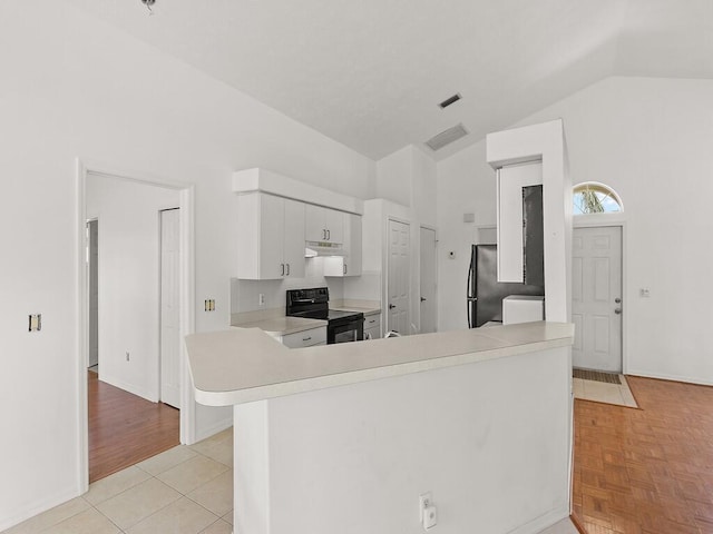 751 SE Majestic Ter, Port Saint Lucie, FL 34953 - kitchen with black appliances, light countertops, white cabinets, under cabinet range hood, and high vaulted ceiling