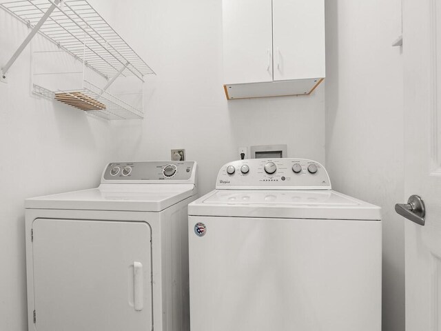 751 SE Majestic Ter, Port Saint Lucie, FL 34953 - laundry area featuring washing machine and clothes dryer and cabinet space