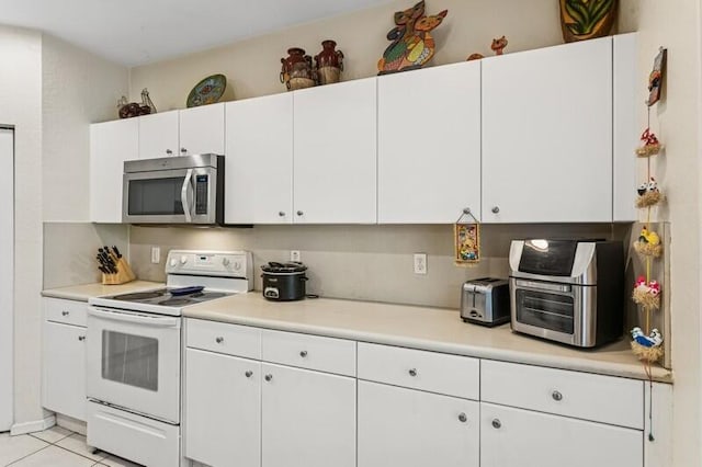 315 Spruce St, Boynton Beach, FL 33426 - kitchen featuring stainless steel microwave, white range with electric stovetop, light countertops, and white cabinets