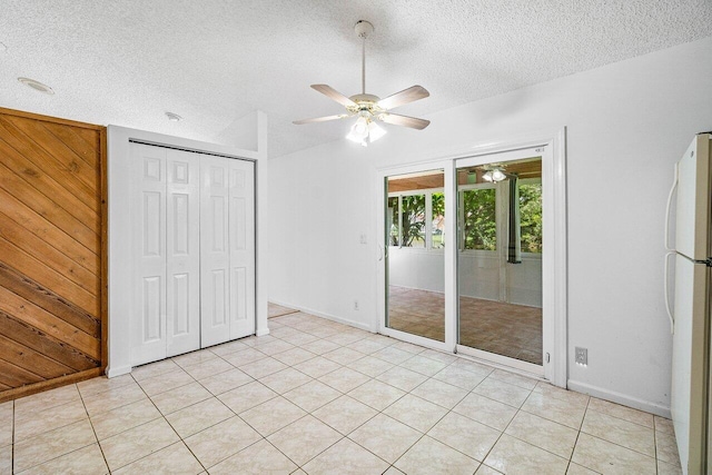 145 Waterway Rd, Royal Palm Beach, FL 33411 - unfurnished bedroom with freestanding refrigerator, access to exterior, a textured ceiling, a closet, and wooden walls
