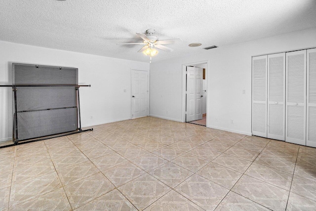 145 Waterway Rd, Royal Palm Beach, FL 33411 - unfurnished bedroom featuring a textured ceiling, light tile patterned flooring, a ceiling fan, and a closet